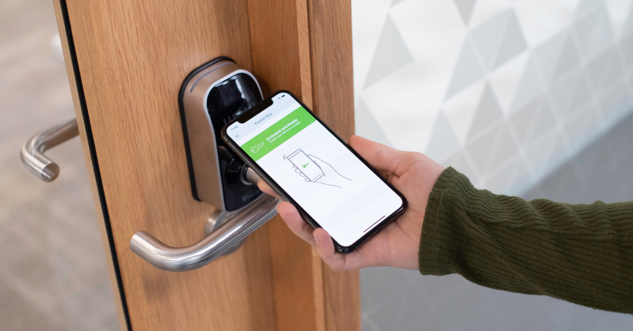 Person unlocking smart door lock with mobile